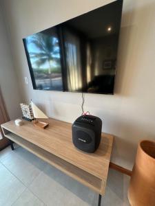 a room with a table with a television on the wall at Refúgio do Igarapé - Atins - Bangalos in Atins