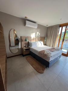 a bedroom with a large bed and a mirror at Refúgio do Igarapé - Atins - Bangalos in Atins +17 photos