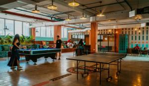 a group of people playing pool in a room with tables at Viajero Casco Viejo Hostel in Panama City