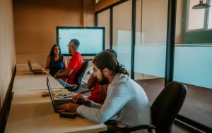 a group of people sitting around a table with laptops at Viajero Casco Viejo Hostel in Panama City
