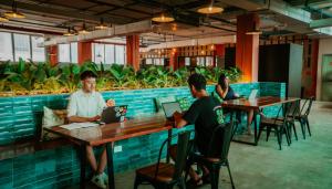 a group of people sitting at tables in a restaurant at Viajero Casco Viejo Hostel in Panama City