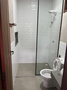 a bathroom with a toilet and a glass shower at Hospedaria Lunar in Palmeiras +14 photos