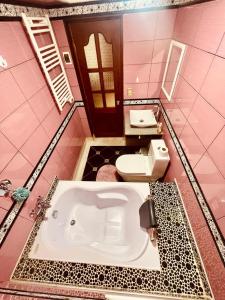 a pink bathroom with a tub and a toilet at Casa de campo x6 de Sayri in Calca +19 photos
