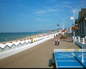 une plage avec une piscine et des gens marchant sur la plage dans l'établissement Appartement à 50 m de la plage avec WIFI, à Villers-sur-Mer 7 autres photos
