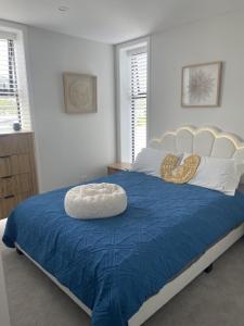 a bedroom with a large bed with a blue comforter at City haven away from home in Nelson