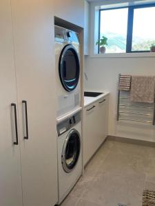 a washer and dryer in a kitchen with a window at City haven away from home in Nelson