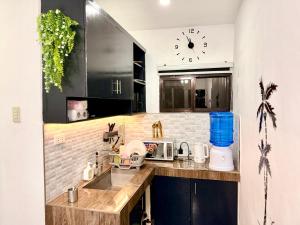 a kitchen with a sink and a clock on the wall at Santa Cosy Villa suite-B Fast Wi-Fi, Netflix Included Split system Air-con & Hot Shower Close to Enchanted Kingdom in Santa Rosa