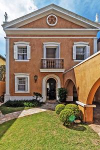 una grande casa di mattoni con un orologio su un balcone di Sobrado top 300m2 house in Jardins 3 suites a San Paolo