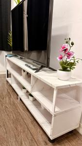 a white entertainment center with a tv on top of it at Santa Cosy Villa B Fast Wi-Fi, Netflix Included Split system Air-con & Hot Shower in Santa Rosa