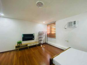 a room with a bed and a flat screen tv at Balai Malipayon in Guiuan