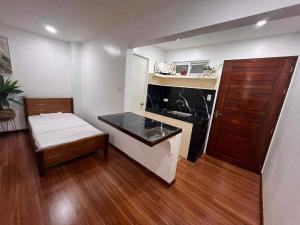 a small room with a kitchen and a bed in it at Balai Malipayon in Guiuan