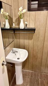 a bathroom with a sink and two vases with flowers at Santa Cosy Villa suite-B Fast Wi-Fi, Netflix Included Split system Air-con & Hot Shower Close to Enchanted Kingdom in Santa Rosa +21 photos