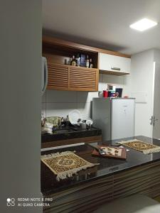 a kitchen with a counter top and a refrigerator at Apartamento Porto das dunas in Aquiraz