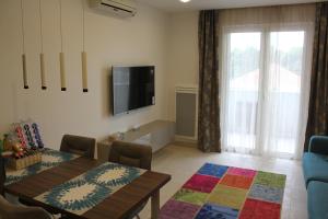 a living room with a dining table and a television at Apartment Patricia in Vodice