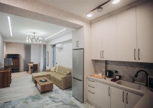 a kitchen and living room with a couch and a table at Sabah Bayil Residence Family Apart in Baku