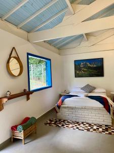 un dormitorio con una cama y una ventana en Bangalô Charme Serra do Cipó, en Santana do Riacho