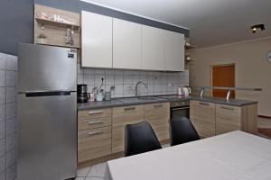 a kitchen with a refrigerator and a table with chairs at Apartments and rooms with parking space Vrbnik, Krk - 5302 in Vrbnik