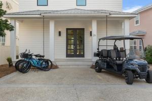 un carro de golf estacionado frente a una casa con bicicletas en NEW Bikinis & Martinis Private Pool Gulf Views Bikes LSV, en Santa Rosa Beach 125 fotos más