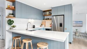 a kitchen with blue walls and white countertops at The Salty Perch in Callala Beach
