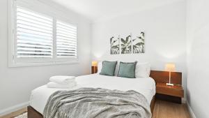 a white bedroom with a bed and a window at The Salty Perch in Callala Beach +33 photos