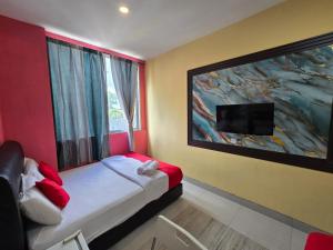 a bedroom with a bed with a large painting on the wall at First In Hotel in Bandar Saujana Putra
