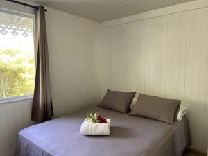a bedroom with a bed with a flower on it at Fare Torehau Tiahura in Hauru