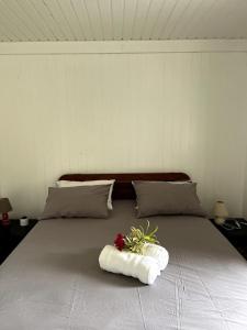a bed with a bouquet of flowers on it at Fare Torehau Tiahura in Hauru