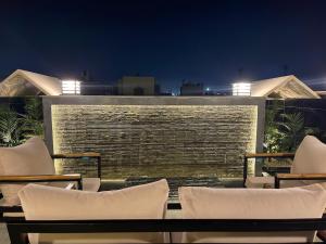 a group of chairs sitting on a patio at night at Brand New Apartment Obour City in Obour