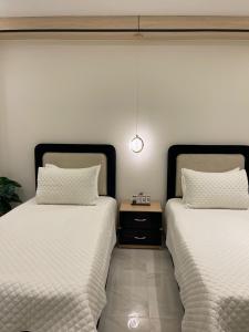 zwei Betten nebeneinander in einem Zimmer in der Unterkunft Brand New Apartment Obour City in Obour