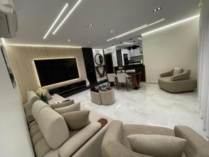 a living room with two couches and a television at Brand New Apartment Obour City in Obour