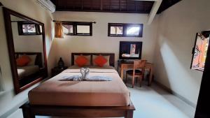 Un dormitorio con una cama con una mesa y una silla. en Sahadewa House, en Ubud