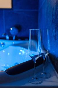 サン・テティエンヌにあるBeige Hospitalité - Ruby - Love Room - Netflixのワイングラス2杯(バスタブの横のテーブルに座る)