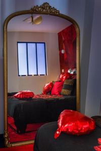 サン・テティエンヌにあるBeige Hospitalité - Ruby - Love Room - Netflixのベッドルーム1室(鏡、赤い枕付きのベッド1台付)