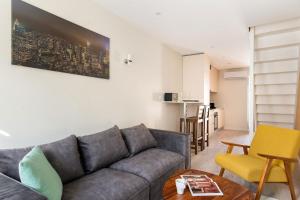 a living room with a couch and a table at Beige Hospitalité - Agathe - Le nid Urbain in Saint-Étienne