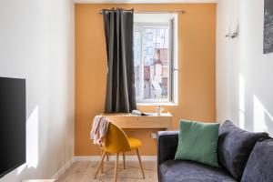 a living room with a couch and a window at Beige Hospitalité - Agathe - Le nid Urbain in Saint-Étienne