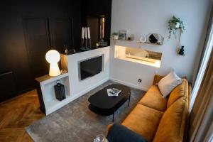 a living room with a couch and a tv at Simone hypercentre ultra haut de gamme in Saint-Étienne