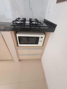 a kitchen with a counter with a stove top oven at Apartamento Alto de São Manoel in Mossoró