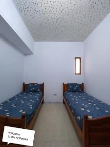 Zimmer mit 2 Betten in einem Zimmer mit einer Decke in der Unterkunft maison de baraka in Al Ḩārah al Kabīrah