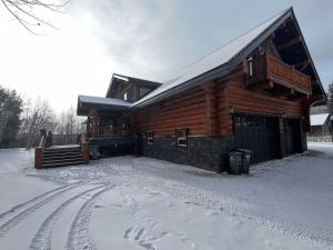 a log cabin in the snow with footprints in the snow at Southview Lodge in Valemount