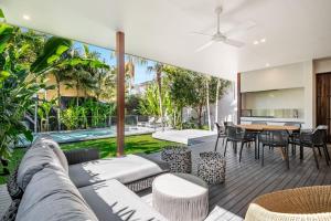 an indoor patio with a table and chairs and a pool at Alpha Luxe - Pet Friendly Luxury Home and Heated Pool in Byron Bay