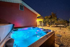 a hot tub on the side of a house at night at Arrowleaf Family House with Hot Tub in Kanab