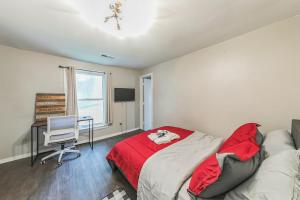 a bedroom with a bed with a red blanket and a desk at Lux Stay - 3mins to UC Medical & DT Cincinnati in Cincinnati