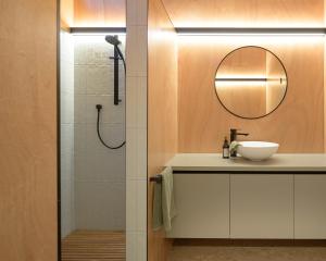 a bathroom with a sink and a shower with a mirror at Lakefront Luxury at Okere Falls Lake Rotoiti in Rotorua +28 photos