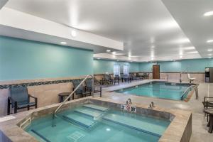 a swimming pool with tables and chairs in a building at Best Western Plus Rapid City Rushmore in Rapid City