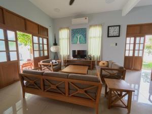 a living room with a couch and a table at D SeBalik Pulau Tropical Boutique Home in Balik Pulau