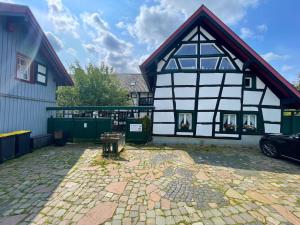 a black and white building with a bench in front of it at Ferienhaus Emma im Morsbacher Hof in Morsbach