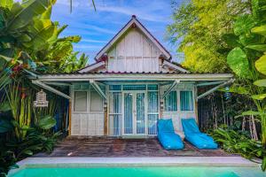 ein kleines Haus mit blauen Kissen davor in der Unterkunft SooBali Mint Cottage Sanur 1BR in Sanur