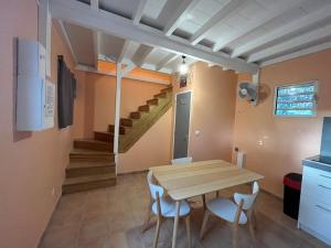 a dining room with a table and chairs and a staircase at Tiny house campagne proche plages in Quartier Morne Acajou