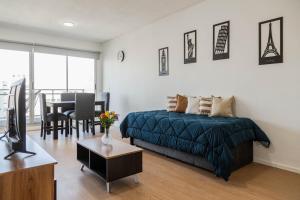 Un dormitorio con una cama y una sala de estar con una mesa. en Confort Palermo Hollywood, en Buenos Aires 30 fotos más