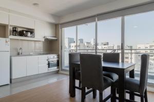 cocina con mesa y sillas y ventana grande en Confort Palermo Hollywood, en Buenos Aires